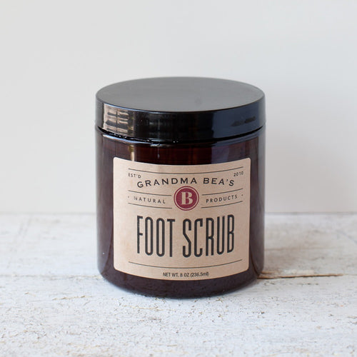 Amber jar with black lid containing handcrafted foot scrub with natural ingredients, featured in Health & Wellness, Balms, Creams and Lotions, USA Made, Best Sellers, and Promo Eligible collections.