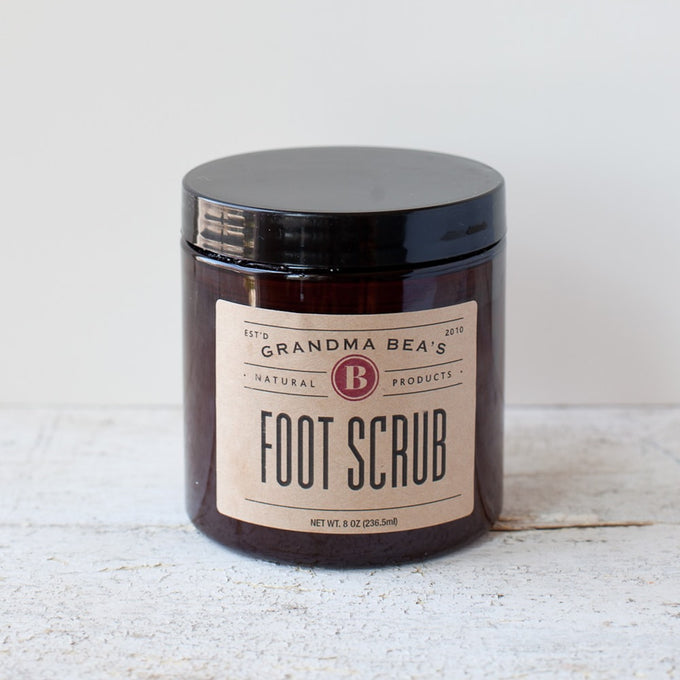 Amber jar with black lid containing handcrafted foot scrub with natural ingredients, featured in Health & Wellness, Balms, Creams and Lotions, USA Made, Best Sellers, and Promo Eligible collections.
