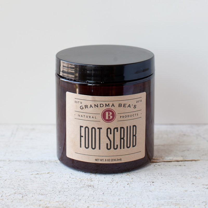Amber jar with black lid containing handcrafted foot scrub with natural ingredients, featured in Health & Wellness, Balms, Creams and Lotions, USA Made, Best Sellers, and Promo Eligible collections.