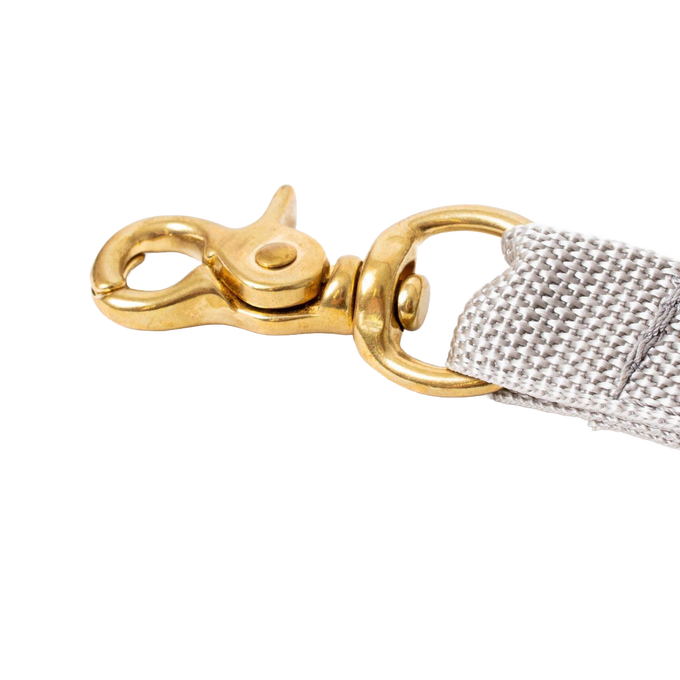 Brass snap hook attached to a beige woven strap, handcrafted and Amish made, ideal for securing clothespin bags in Home & Decor and Clothesline Accessories collections.