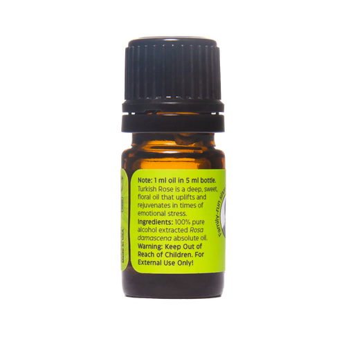 Small amber glass bottle with black cap containing 100% pure Turkish Rose absolute oil, featuring a bright green label with usage and ingredient details, part of Health & Wellness and USA Made collections.