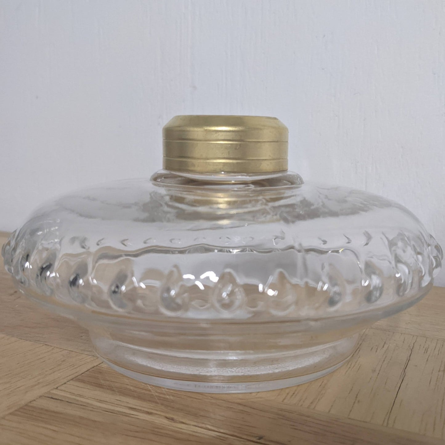 Clear glass bracket lamp font with a brass collar, featuring decorative embossing, handcrafted for use in lamps & lighting, oil lamps, wall lamps, and best sellers collections.