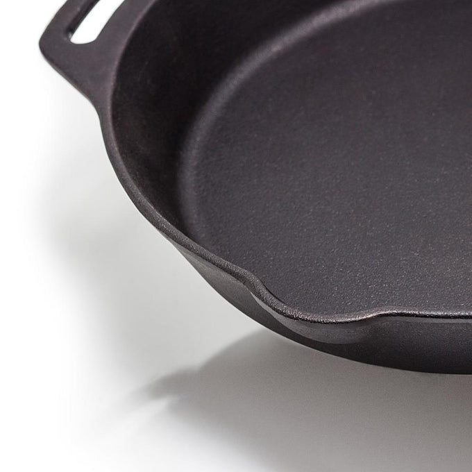 Close-up of a handcrafted cast iron skillet with two sturdy side handles and a pouring spout, ideal for use in farm, kitchen, camping, cookware, and cast iron collections.