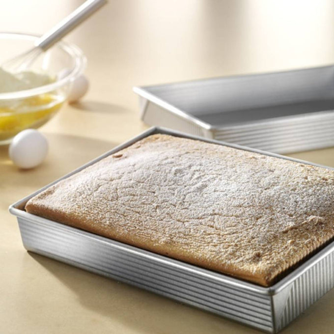 Rectangular baking pan made in USA with recycled steel and a unique corrugated surface, shown with a fresh baked cake, ideal for Kitchen & Food, Cookware, Baking Supplies, and Best Sellers collections.