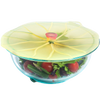 Silicone reusable bowl cover shaped like a lily pad sealing a glass bowl filled with fresh salad, featured in Kitchen & Food and Storage and Serving collections.