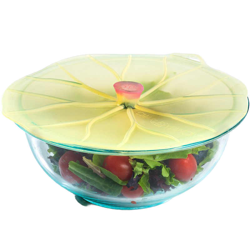 Silicone reusable bowl cover shaped like a lily pad sealing a glass bowl filled with fresh salad, featured in Kitchen & Food and Storage and Serving collections.