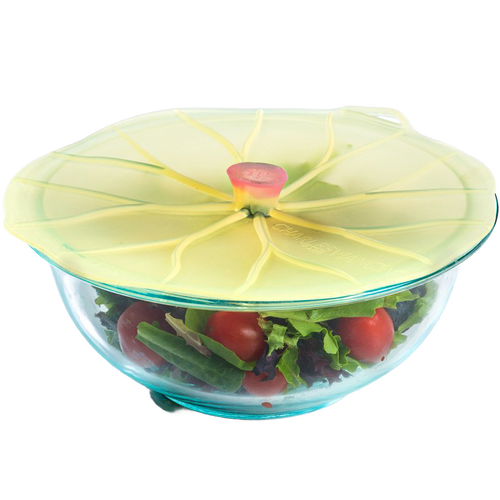 Silicone reusable bowl cover shaped like a lily pad sealing a glass bowl filled with fresh salad, featured in Kitchen & Food and Storage and Serving collections.