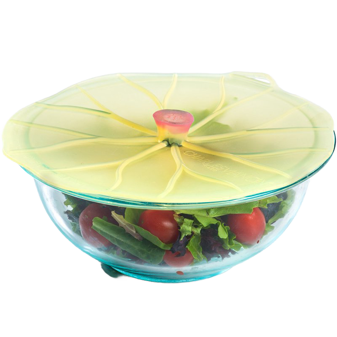 Silicone reusable bowl cover shaped like a lily pad sealing a glass bowl filled with fresh salad, featured in Kitchen & Food and Storage and Serving collections.