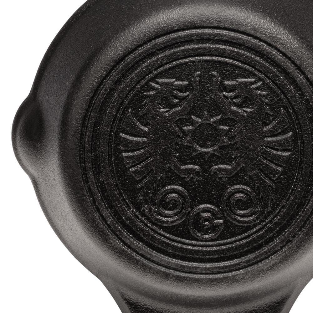 Close-up of a handcrafted cast iron skillet with two side handles featuring an embossed detailed emblem, ideal for cooking in camping, kitchen, and farm settings.