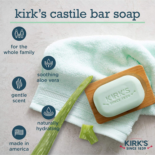 Light green bar of Kirk's Castile soap resting on a wooden soap dish with folded white towel and aloe vera leaf pieces, highlighting gentle scent, soothing aloe vera, and made in America benefits for health and grooming.