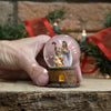 Handcrafted miniature glitter snow globe featuring a detailed Holy Family scene inside a glass dome with a wood-textured base, perfect for Home & Decor and Holiday Decor collections.