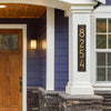 Handcrafted vertical address plaque in aged bronze with modern numbers mounted on a white pillar, enhancing curb appeal in Home & Decor and USA Made collections.