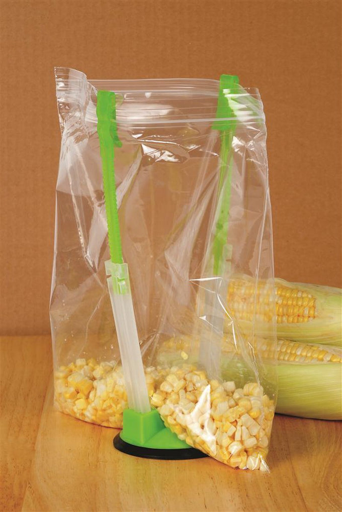 Green and clear plastic bag holder with suction base securing a zipper storage bag open for easy hands-free filling of corn kernels, featured in Kitchen & Food, Kitchen Gadgets, Cooking and Baking Helpers, Best Sellers, and Promo Eligible collections.