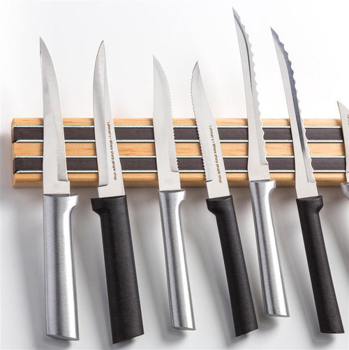Handcrafted heavy duty hardwood magnetic knife rack holding an assortment of kitchen knives with metal and black handles, ideal for kitchen, food prep, and tool organization.