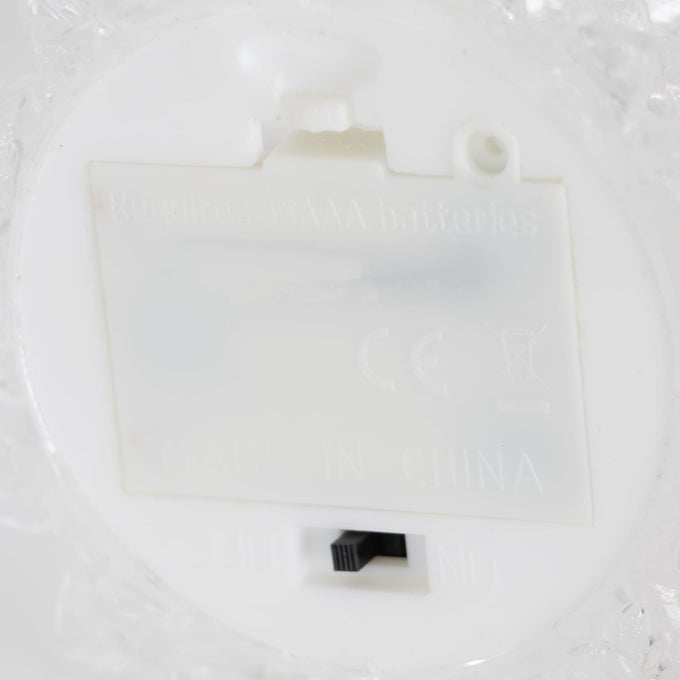 Close-up view of the battery compartment and on/off switch on a clear acrylic Christmas tree base, designed for indoor holiday decor in Home & Decor and Holiday collections.