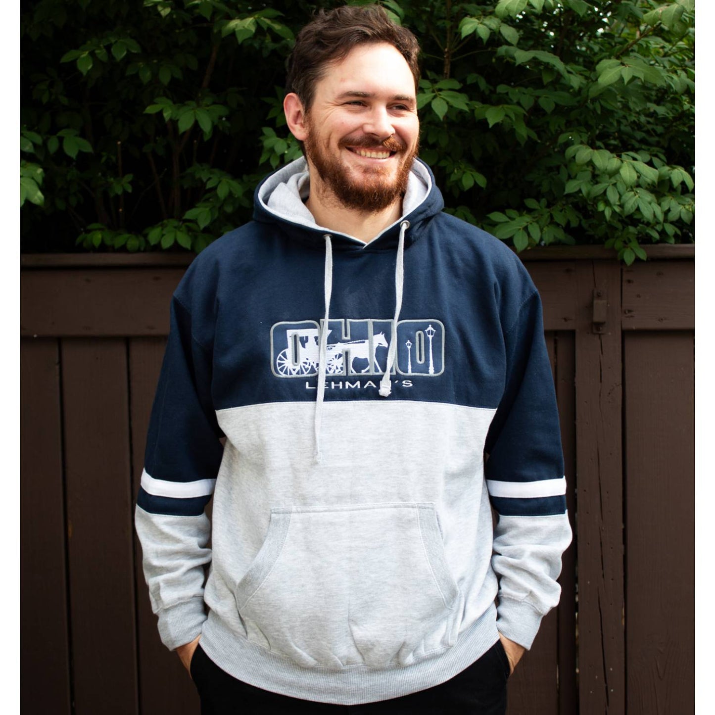 Man wearing a handcrafted navy and gray fleece hoodie with unique Ohio-themed embroidery and arm stripes, part of Lehman's Health & Wellness and Clothing collections