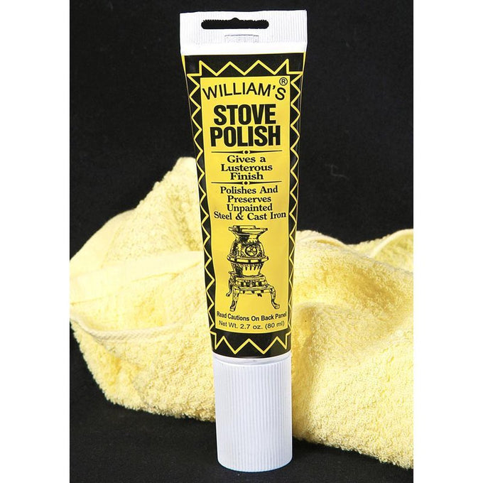 Tube of black satin semi-paste stove polish designed to polish and preserve unpainted steel and cast iron, displayed with a soft yellow cleaning cloth in home and decor setting.