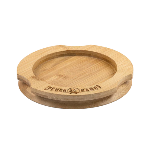 Handcrafted bamboo coaster with engraved Feuerhand logo, designed to protect surfaces from oil residues, ideal for lamps and outdoor use, featured in Camping, Emergency Supplies, and Best Sellers collections.
