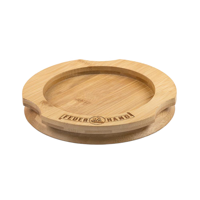 Handcrafted bamboo coaster with engraved Feuerhand logo, designed to protect surfaces from oil residues, ideal for lamps and outdoor use, featured in Camping, Emergency Supplies, and Best Sellers collections.