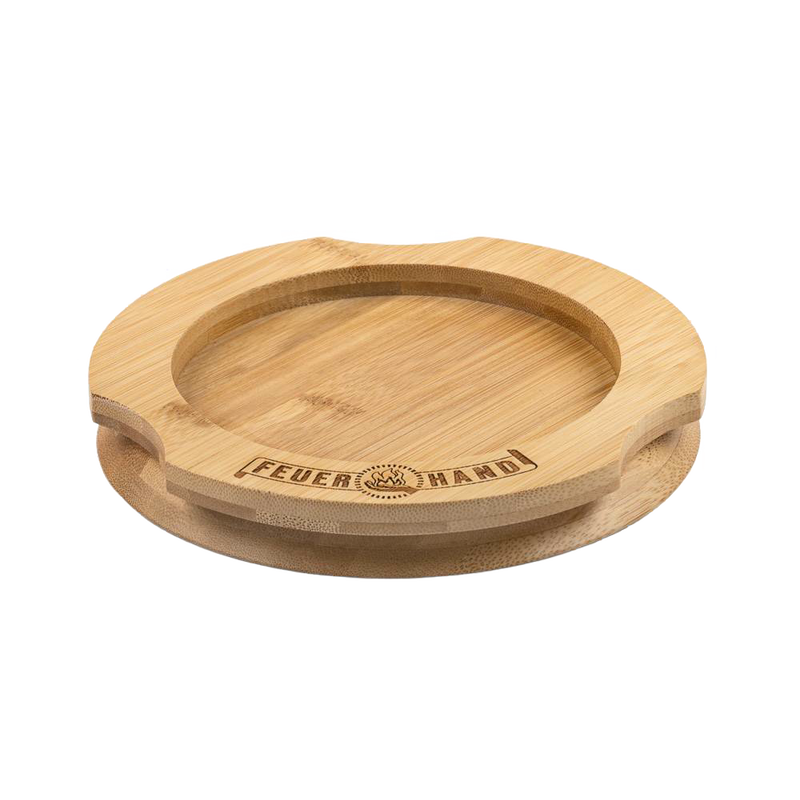 Handcrafted bamboo coaster with engraved Feuerhand logo, designed to protect surfaces from oil residues, ideal for lamps and outdoor use, featured in Camping, Emergency Supplies, and Best Sellers collections.