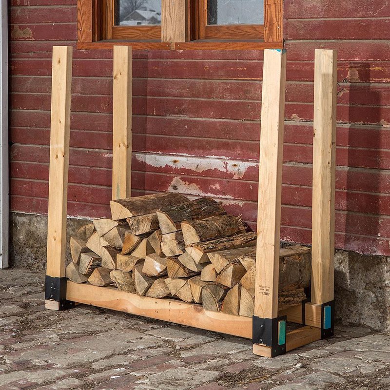 Handcrafted wooden log stacker with durable metal brackets holding firewood off the ground, designed for farm, garden, wood cutting, and homesteading use.