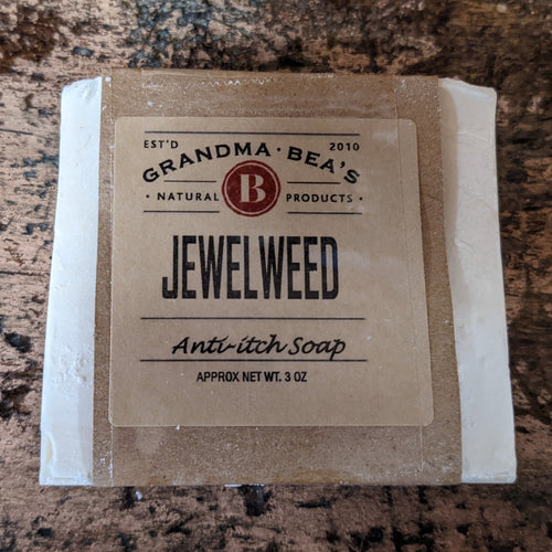 Bar of handcrafted jewelweed anti-itch soap wrapped in simple brown paper packaging, featuring natural, USA made wellness product branding for health remedies and soaps collections.