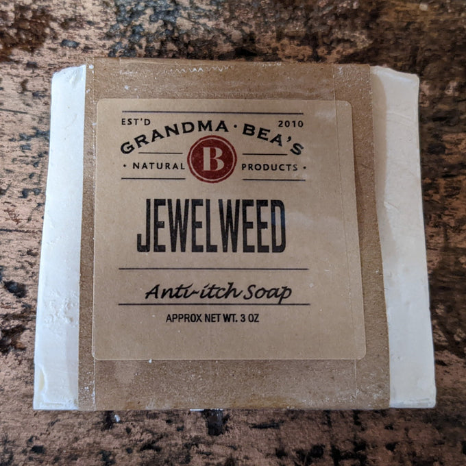 Bar of handcrafted jewelweed anti-itch soap wrapped in simple brown paper packaging, featuring natural, USA made wellness product branding for health remedies and soaps collections.