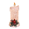 Handcrafted lighted candle with textured glitter body, topped with faux melted wax and a glowing flame, featuring a detailed cardinal and holly sprig at its base, ideal for Home & Decor, Holiday Decor, Best Sellers, and Promo Eligible collections.