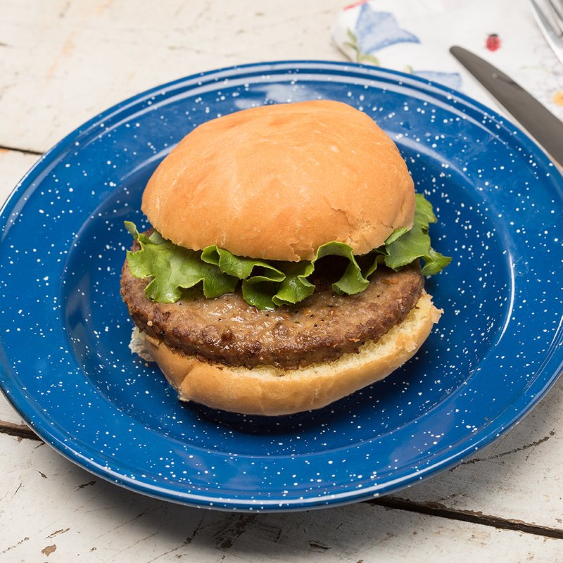 Cooked hamburger patty with fresh green leaf lettuce on a soft bun, served on a rustic blue enamel plate, highlighting classic American comfort food in Kitchen & Food and Meats collections.
