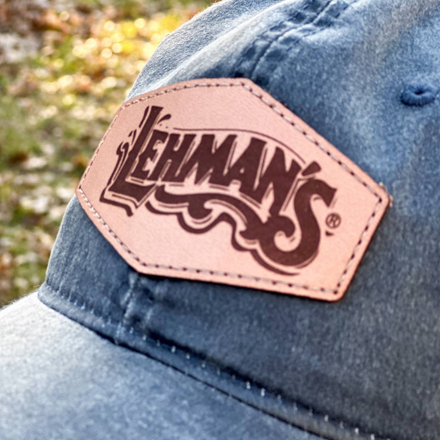 Close-up of a washed cotton adjustable hat featuring a handcrafted light brown leather patch with a vintage-style Lehman's logo, perfect for Health & Wellness, Clothing and Accessories, Best Sellers, and Promo Eligible collections.