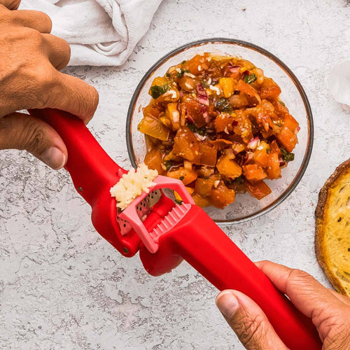 Red Garject Lite Garlic Press efficiently mincing garlic cloves while self-scraping and ejecting peels, perfect for Kitchen & Food, Food Prep, Choppers and Cutters, Kitchen Gadgets, and Cooking and Baking Helpers collections.