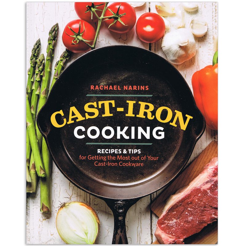 Paperback cookbook titled Cast-Iron Cooking by Rachael Narins, featuring a cast iron skillet surrounded by fresh vegetables and a raw steak, highlighting kitchen and cookware themes.