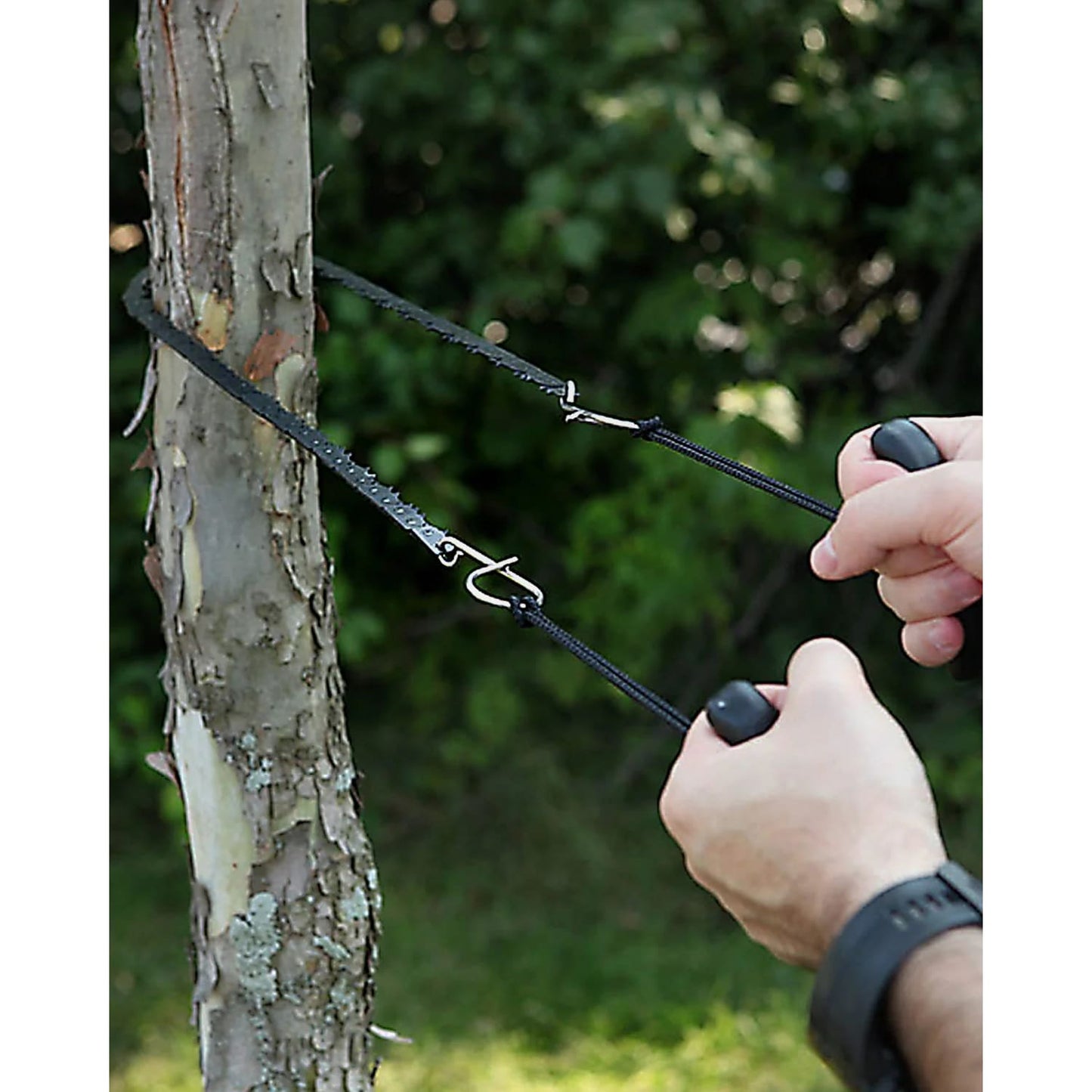 Handcrafted 28-inch pocket saw with heat-treated steel teeth and ergonomic black handles cutting a small tree branch, ideal for farm, garden, wood cutting, and USA Made collections.