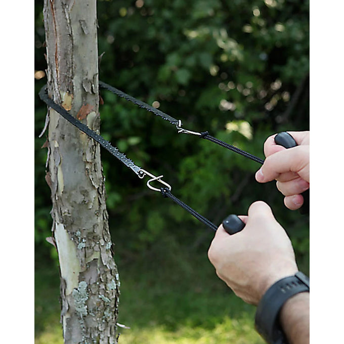 Handcrafted 28-inch pocket saw with heat-treated steel teeth and ergonomic black handles cutting a small tree branch, ideal for farm, garden, wood cutting, and USA Made collections.
