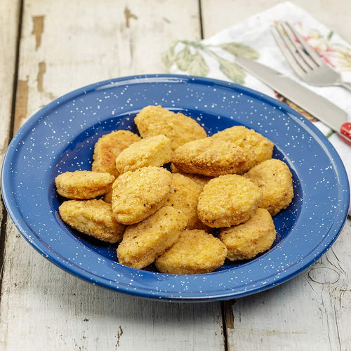 Blue enamelware plate filled with golden brown freeze-dried chicken nuggets on a rustic wooden table, highlighting a long-lasting food option from Kitchen & Food and USA Made collections.