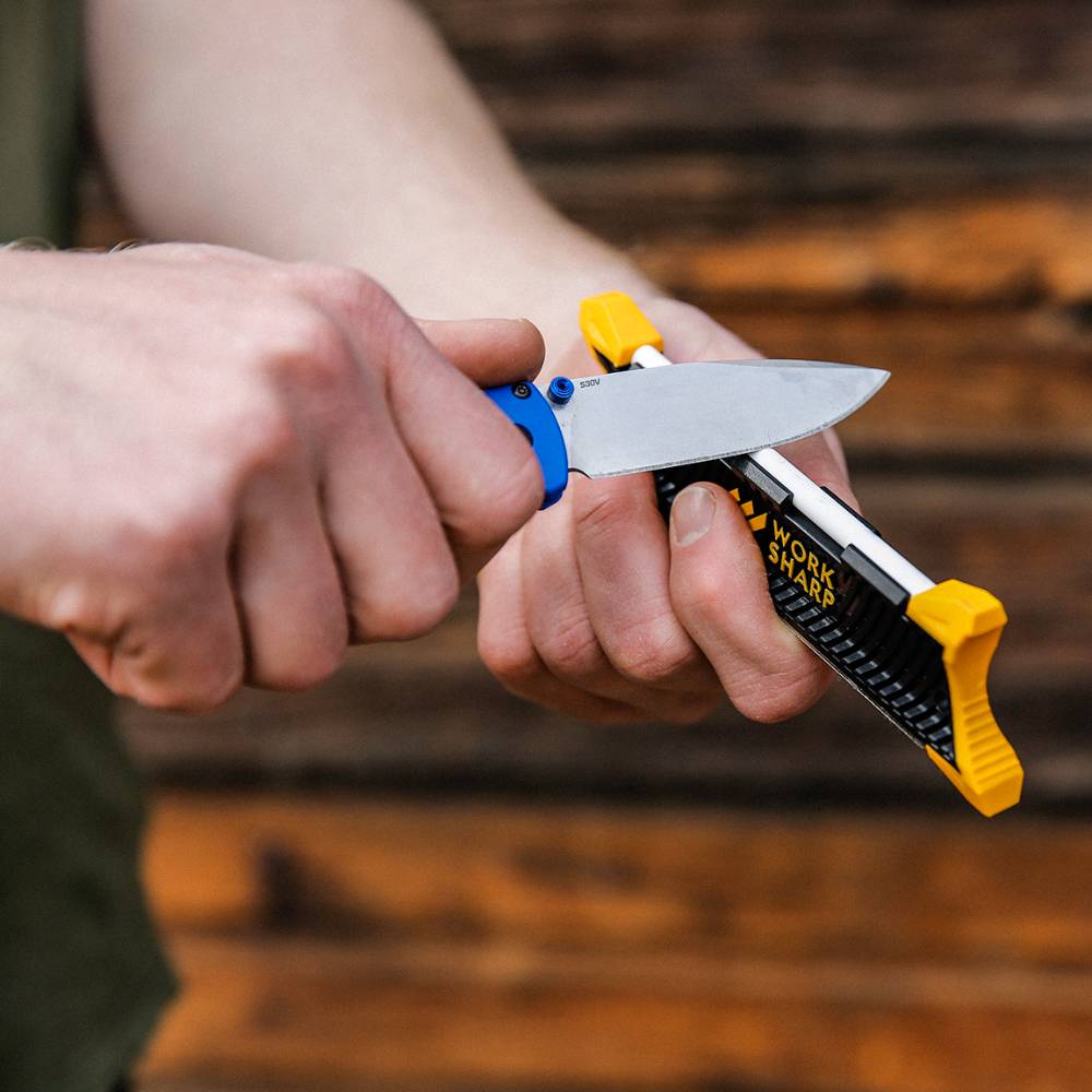 Hands sharpening a fixed-blade knife with a compact Work Sharp Pocket Knife Sharpener featuring yellow guides, ideal for Farm, Garden & Tool, Knives & Axes, and Sharpening collections.