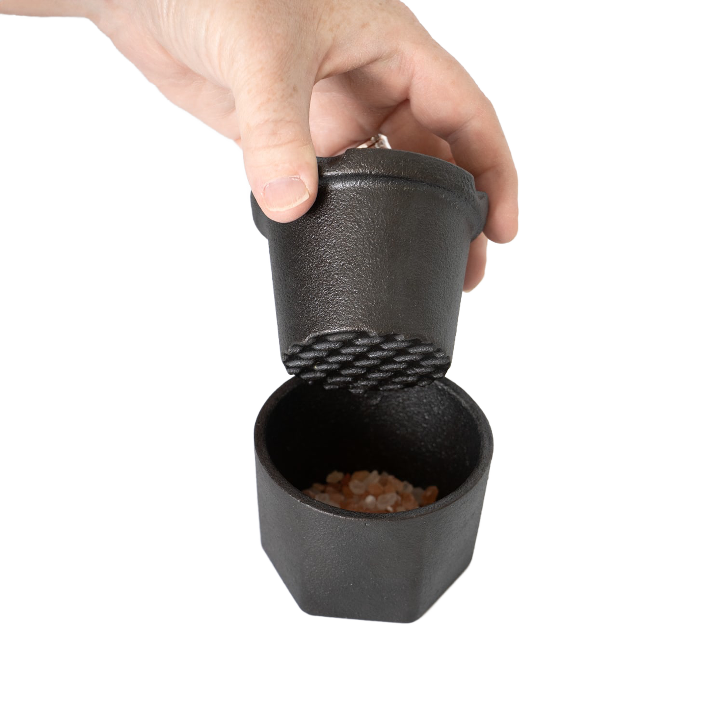 Handheld cast iron spice grinder set with textured grinding surface and bamboo lid, designed to crush coarse pink Himalayan salt crystals, part of Kitchen & Food and Best Sellers collections.