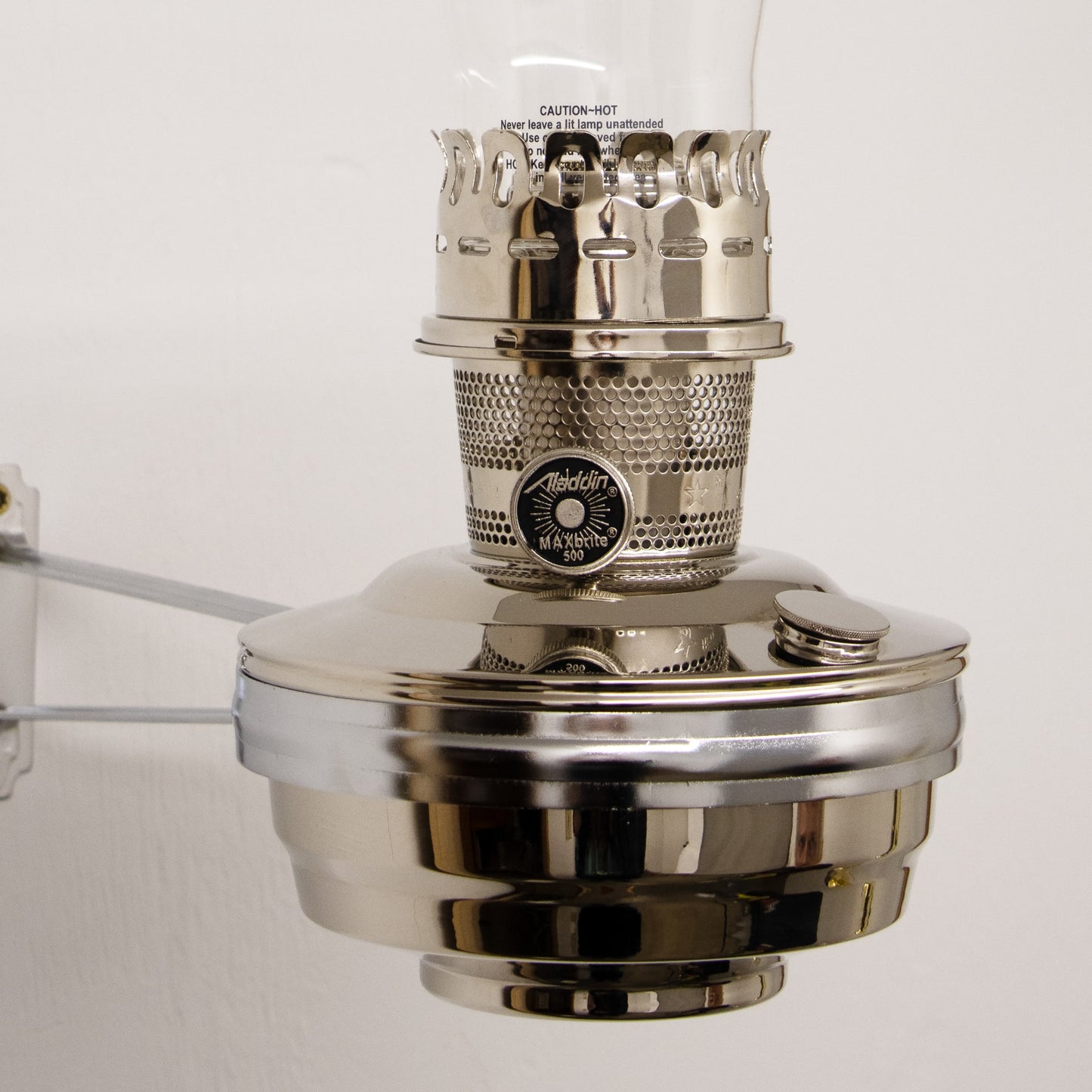 Chrome-plated wall-mounted oil lamp with clear glass chimney and metal burner, providing bright light for farm, garden, emergency, and lighting needs in best sellers and promo collections.