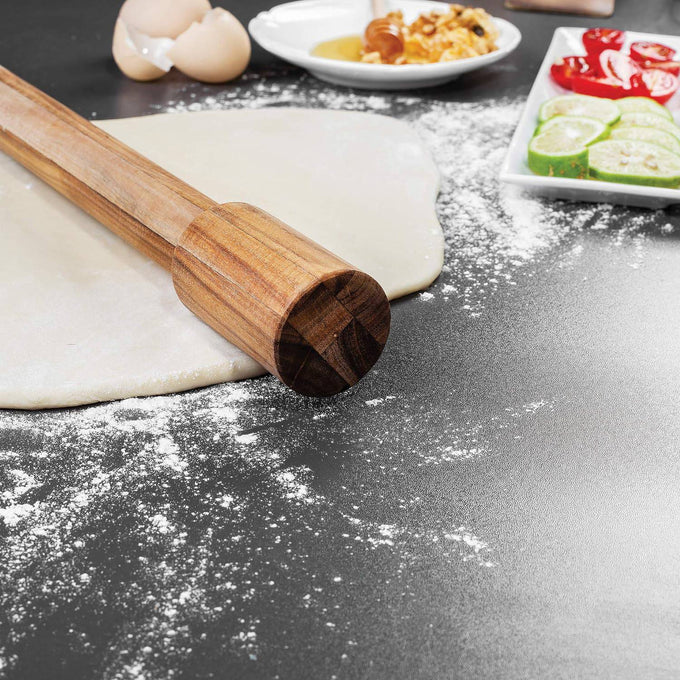 Handcrafted acacia wood rolling pin with fixed handles resting on rolled dough dusted with flour, surrounded by ingredients for baking, ideal for Kitchen & Food, Cookware, Baking Supplies, Best Sellers, and Promo Eligible collections.
