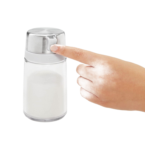 Hand pressing the stainless steel flip-top lid of a clear glass sugar dispenser designed to keep sugar dry and clump-free, perfect for Kitchen & Food, Kitchen Gadgets, and Storage collections.