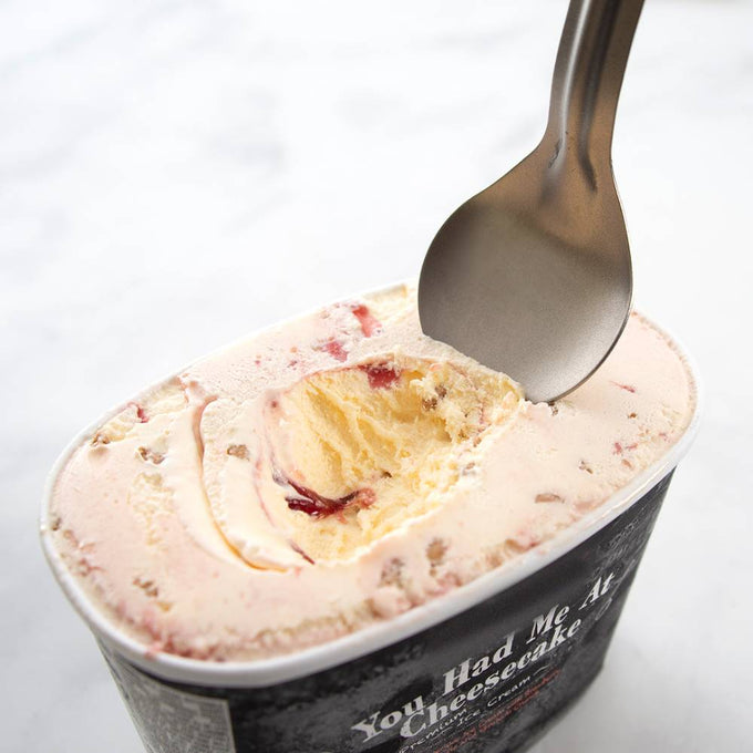Sturdy stainless steel ice cream scoop digging into a container of cheesecake-flavored ice cream, designed for hard-packed scooping in Kitchen & Food, Specialty Equipment, and USA Made collections.