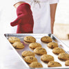 Red heat-resistant glove with silicone grip holding a baking sheet of freshly baked chocolate chip cookies, ideal for Kitchen & Food, Stoves, Kitchen Gadgets, Grilling, and Cooking Helpers collections.