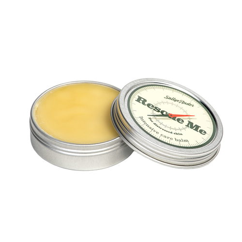 Open metal tin of handcrafted balm with pale yellow ointment inside and a cream-colored lid labeled in green and red, ideal for Health & Wellness and USA Made collections.
