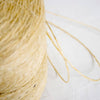 Close-up of natural sisal binder twine in a roll, showing the fibrous texture of durable hemp, ideal for farm, garden, and tool use in sustainable gardening and bundling tasks.