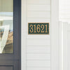 Green and gold custom address plaque mounted on white siding near a modern black door, handcrafted in the USA, featured in Home & Decor, Mailboxes and Address Signs, and Best Sellers collections.