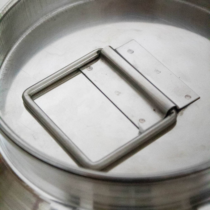Close-up of a seamless 304 grade stainless steel milk can lid with a sturdy square handle, showcasing durable construction for easy use and cleaning in farm, garden, and animal care collections.