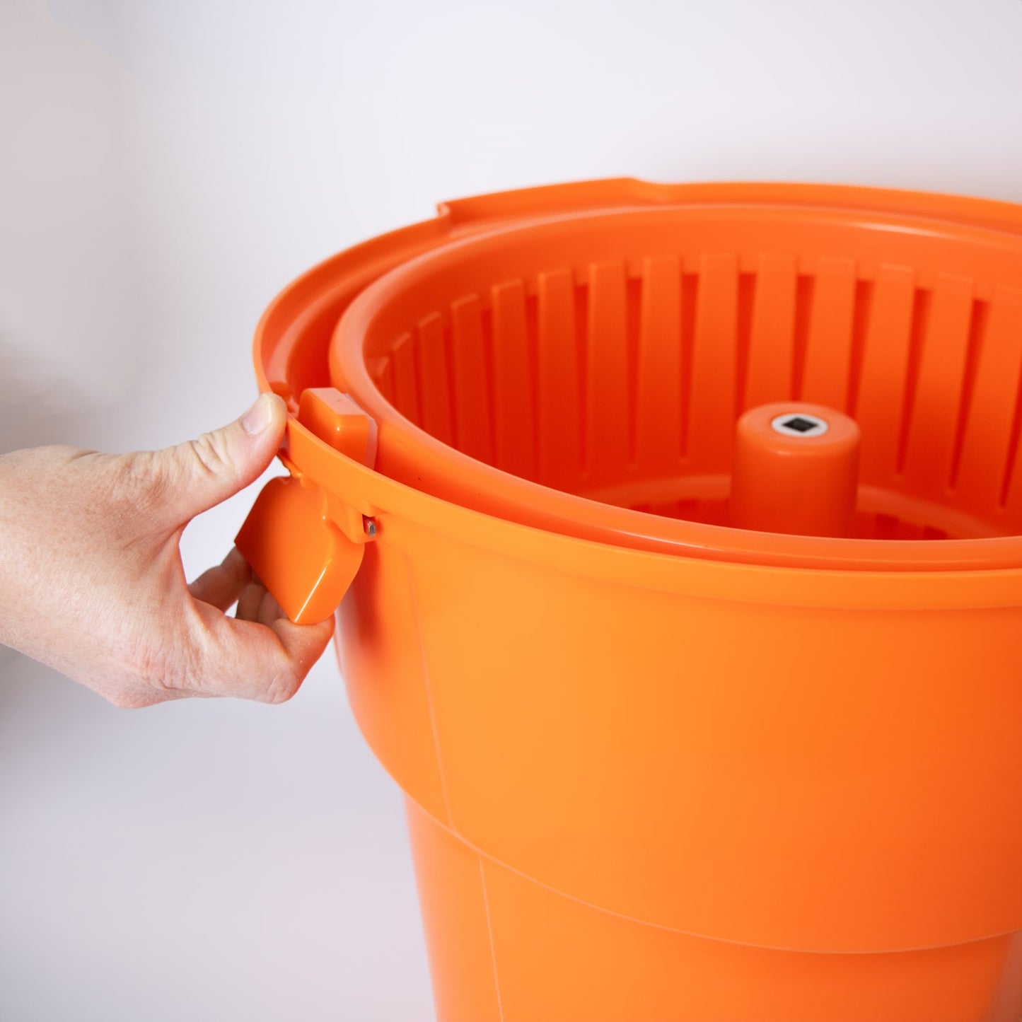 Handcrafted orange laundry spinner bucket with sturdy handle being held, designed for faster drying, featured in Home & Decor, Laundry Supplies, and Best Sellers collections.