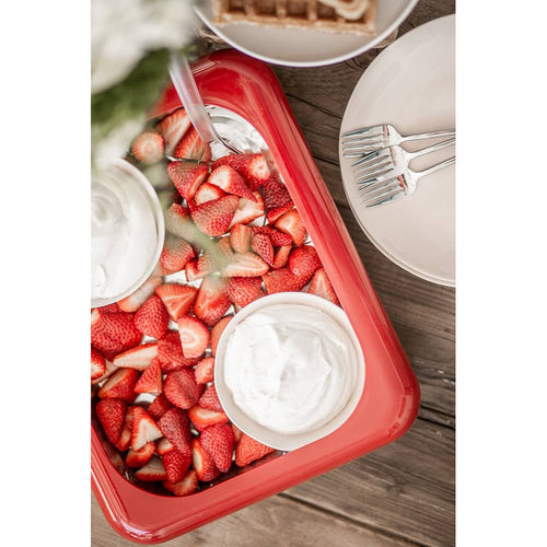Bright red rectangular ceramic dish filled with freshly sliced strawberries and two bowls of whipped cream, set on a rustic wood table with white plates and forks, featured in Kitchen & Food, Kitchen Accessories, and Storage and Serving collections.