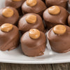 Close-up of smooth milk chocolate-covered peanut butter confections with creamy peanut butter dollops on top, handcrafted in Ohio's Amish Country, featured in Kitchen & Food and USA Made collections.