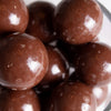 Close-up of glossy milk chocolate malted milk balls featuring a smooth rich coating, perfect for Kitchen & Food, Snacks and Sweets, Candy, USA Made, and Best Sellers collections.